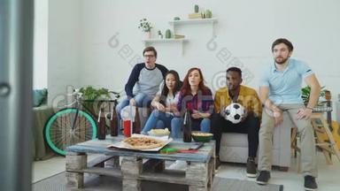 多民族朋友体育迷在电视上看体育比赛，一起在家吃零食喝啤酒